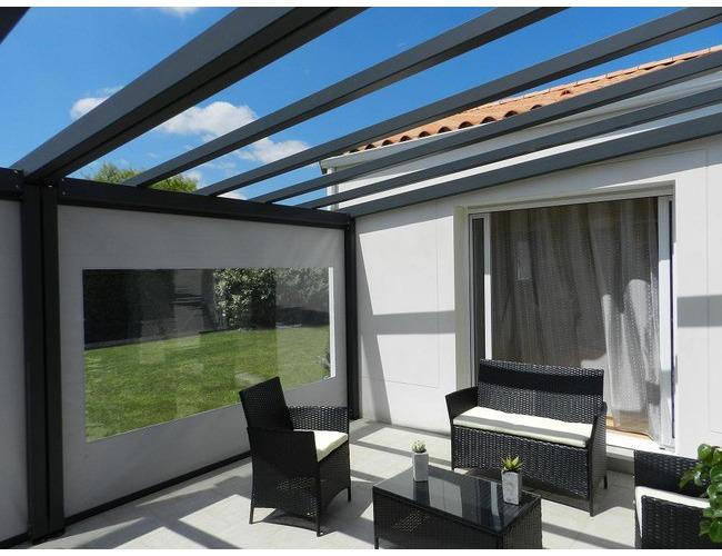 Une pergola VISIUM
En position ouverture avec fermeture lat&eacute;rale et frontale par store &agrave; enroulement &eacute;lectrique SOLIZIP (syst&egrave;me brevet&eacute;)